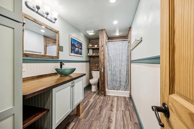 bathroom with vanity, toilet, wood-type flooring, and a shower with curtain