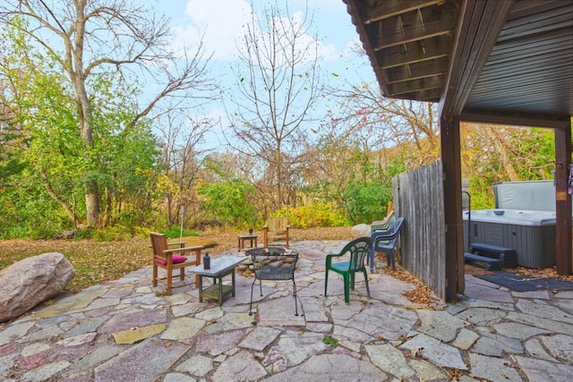 view of patio / terrace with a hot tub and an outdoor fire pit