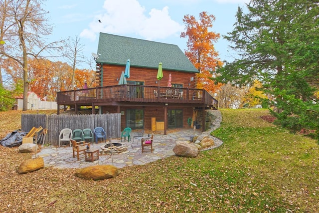 rear view of house featuring an outdoor fire pit, a yard, a patio, and a wooden deck