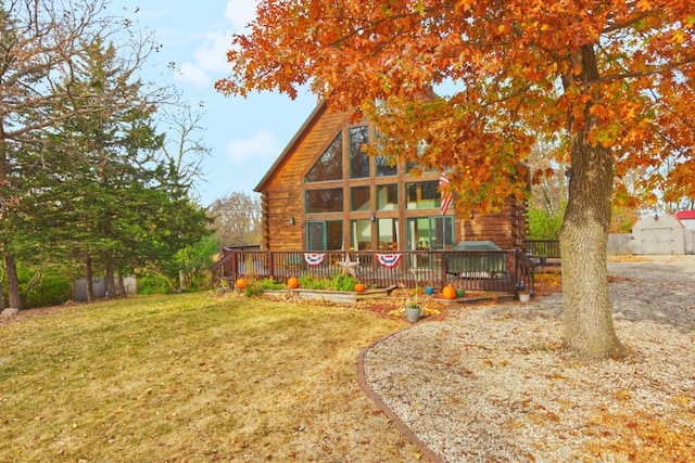 back of house with a shed, a deck, and a lawn