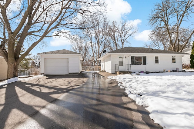 view of front of house featuring an outdoor structure, a garage, and driveway