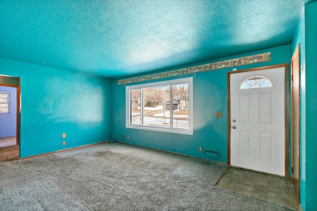 entrance foyer featuring carpet and a textured ceiling