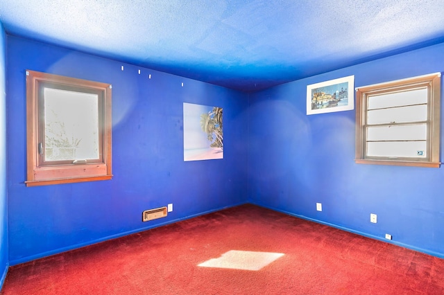 carpeted spare room featuring a textured ceiling