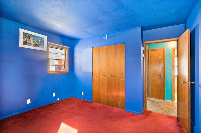 unfurnished bedroom featuring a closet, carpet floors, and a textured ceiling