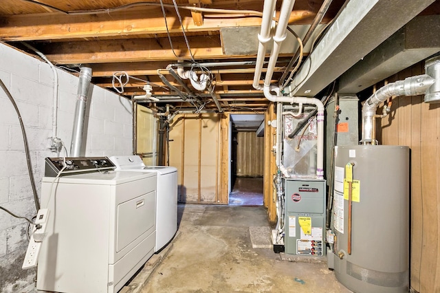 unfinished basement with concrete block wall, independent washer and dryer, and water heater