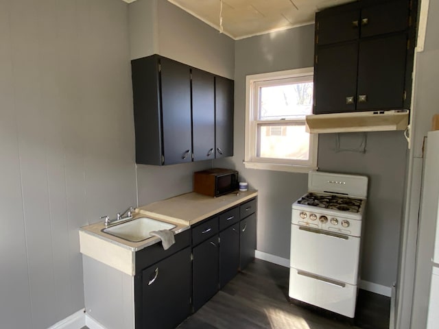 kitchen featuring black microwave, light countertops, white range with gas stovetop, under cabinet range hood, and dark wood-style floors