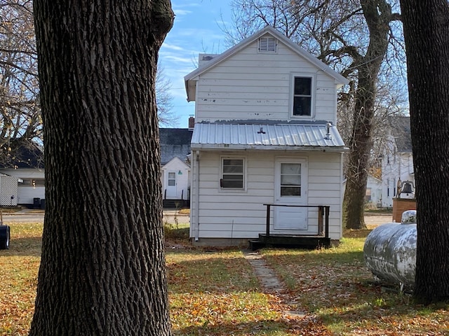 rear view of house featuring heating fuel and metal roof