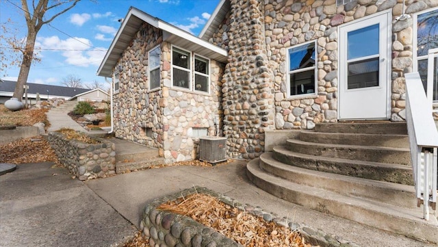 11470 Forada Beach Rd SE, Alexandria, MN 56308 - entrance to property with a patio, stone siding, and cooling unit