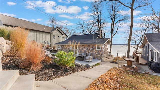 11470 Forada Beach Rd SE, Alexandria, MN 56308 - rear view of property featuring board and batten siding, a patio, a chimney, and stone siding