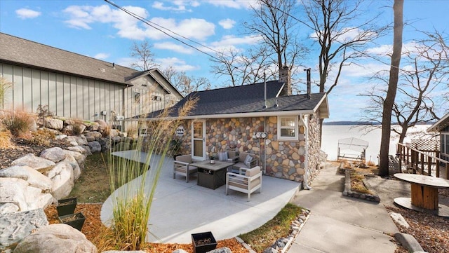 11470 Forada Beach Rd SE, Alexandria, MN 56308 - rear view of property with fence, stone siding, a patio, board and batten siding, and an outdoor fire pit