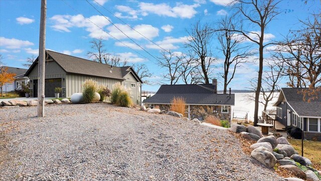 11470 Forada Beach Rd SE, Alexandria, MN 56308 - view of home's exterior with a garage, board and batten siding, a chimney, and gravel driveway