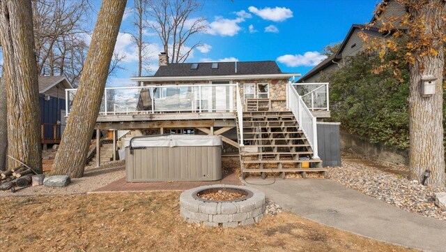 11470 Forada Beach Rd SE, Alexandria, MN 56308 - rear view of house with a hot tub, an outdoor fire pit, a deck, stairway, and a chimney
