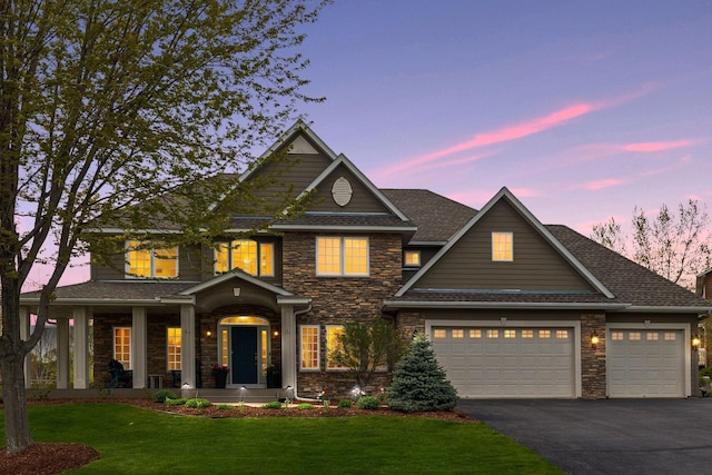 view of front of house featuring a yard, aphalt driveway, a porch, and an attached garage