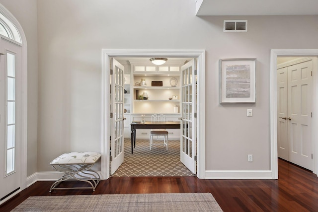 interior space with built in features, french doors, dark wood finished floors, visible vents, and baseboards