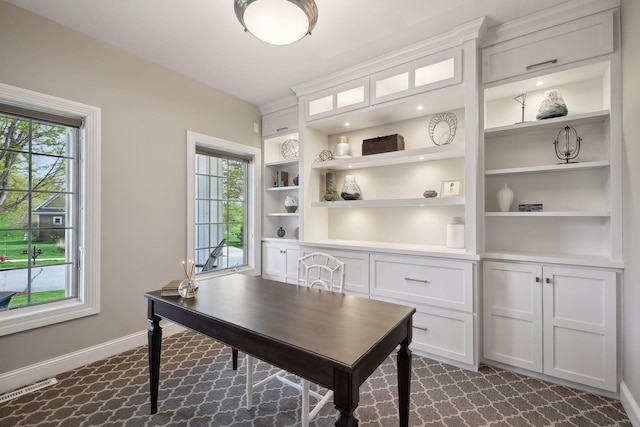 office featuring built in shelves, a wealth of natural light, visible vents, and baseboards