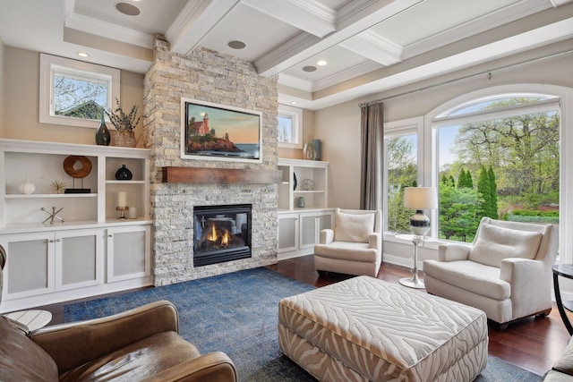 sitting room with beam ceiling, crown molding, a stone fireplace, wood finished floors, and coffered ceiling