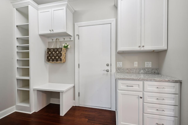 mudroom featuring dark wood-style flooring and baseboards