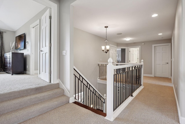 corridor featuring a chandelier, recessed lighting, carpet floors, an upstairs landing, and baseboards