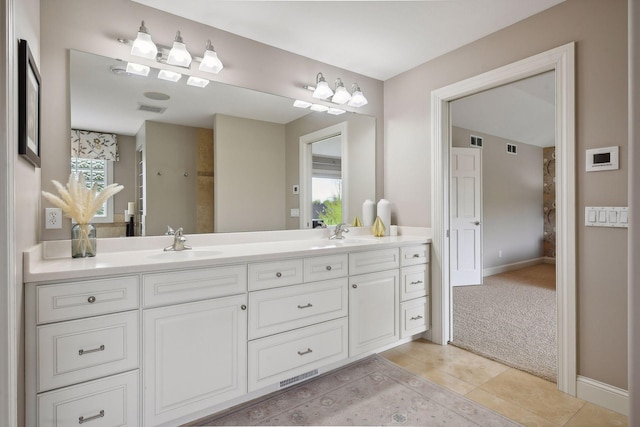 bathroom with double vanity, a sink, visible vents, and tile patterned floors