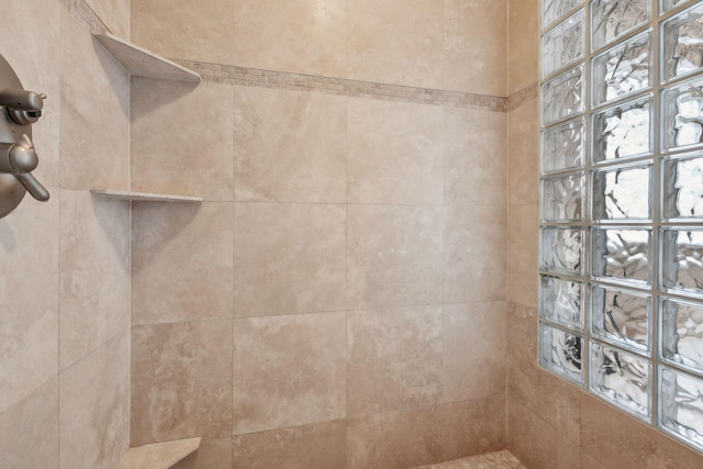 interior details with a tile shower