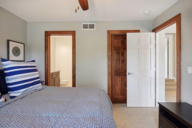 bedroom featuring ceiling fan, connected bathroom, visible vents, and light colored carpet