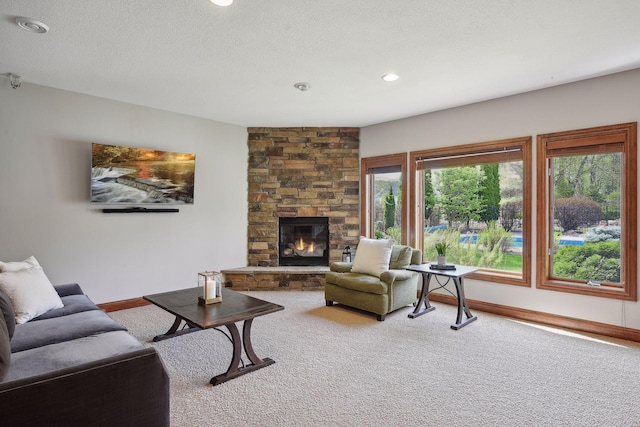 carpeted living area featuring recessed lighting, a fireplace, a textured ceiling, and baseboards