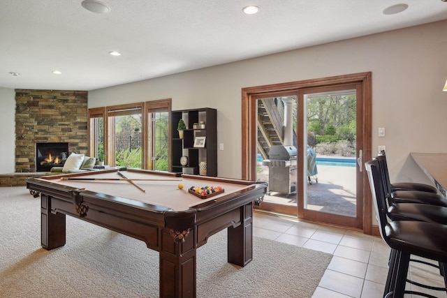 recreation room featuring pool table, a stone fireplace, light tile patterned flooring, and recessed lighting