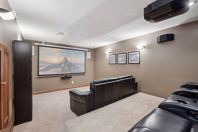 carpeted home theater with a textured ceiling and baseboards