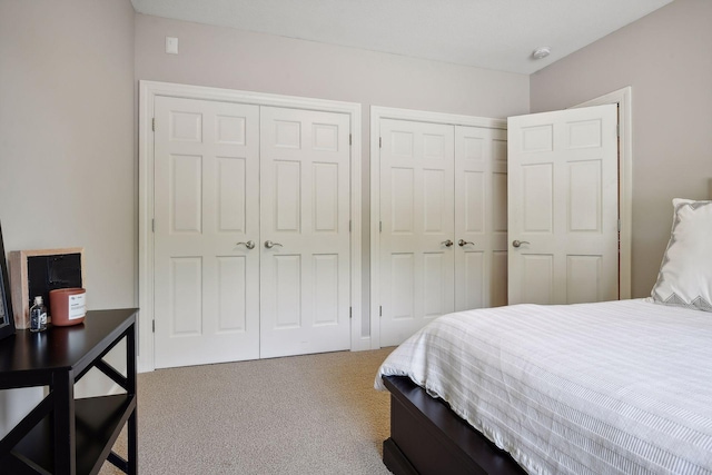 carpeted bedroom featuring two closets