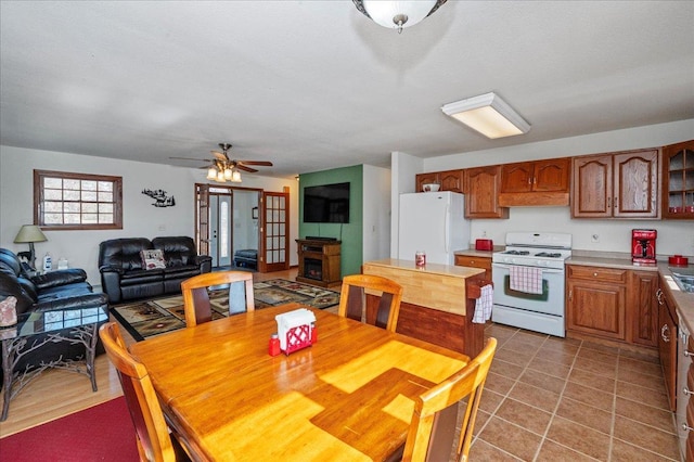 dining space with hardwood / wood-style floors, a fireplace, and ceiling fan