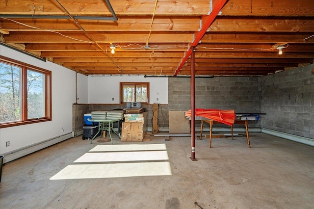 basement with a baseboard radiator and a wealth of natural light