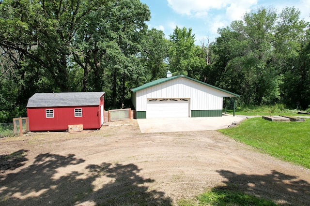 exterior space featuring a lawn, an outdoor structure, a garage, and fence