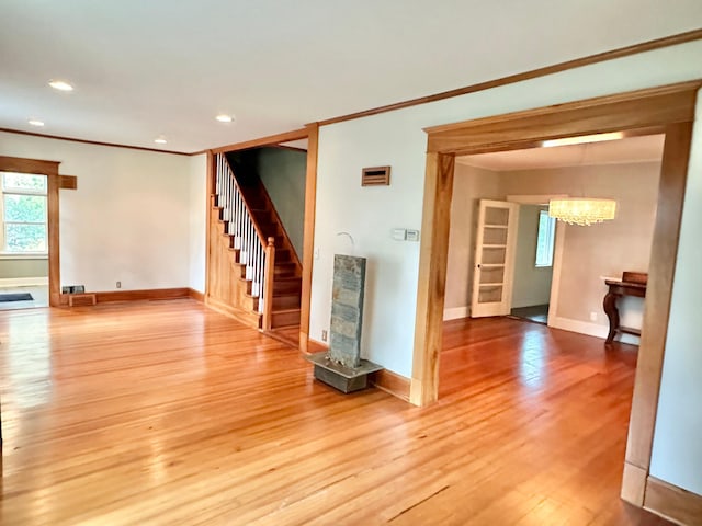 interior space with baseboards, an inviting chandelier, stairs, crown molding, and light wood-type flooring