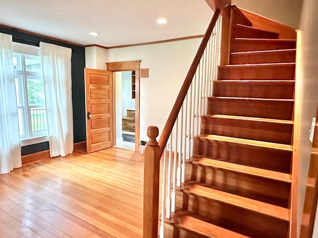 stairs with crown molding, recessed lighting, baseboards, and wood finished floors