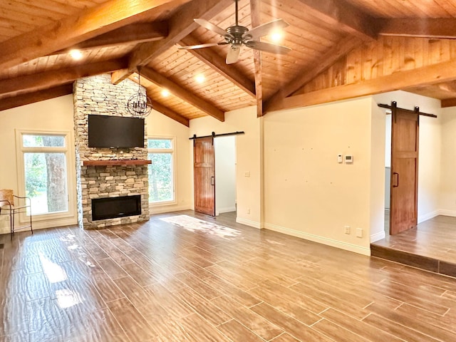 unfurnished living room featuring wood ceiling, a barn door, and vaulted ceiling with beams
