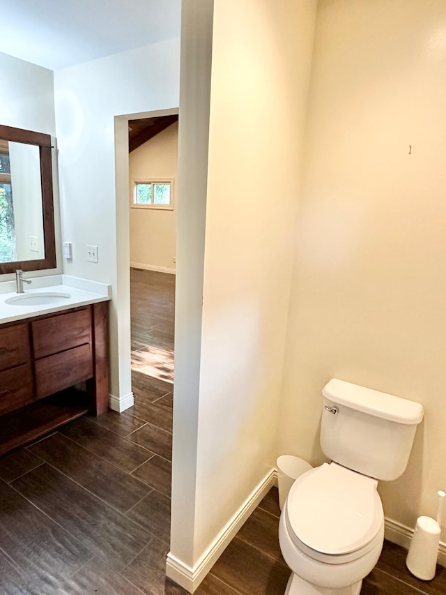 bathroom with vanity, toilet, baseboards, and wood finished floors