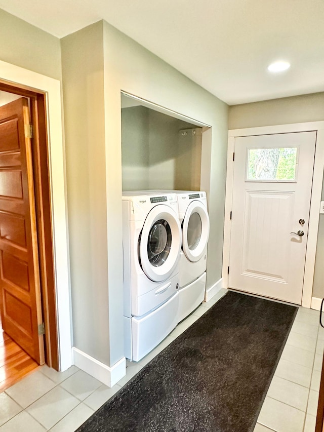 laundry area with independent washer and dryer and light tile patterned floors