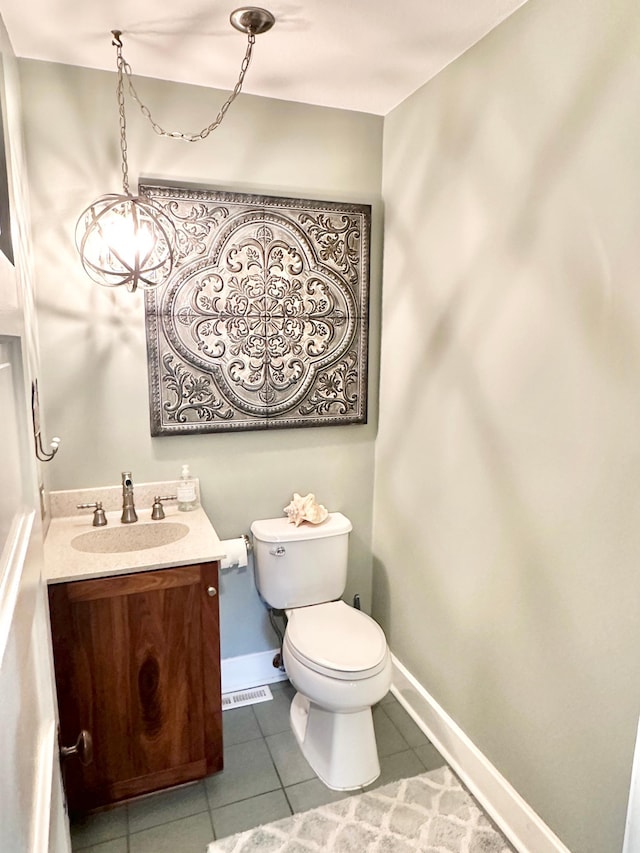 bathroom featuring tile patterned floors, toilet, baseboards, and vanity