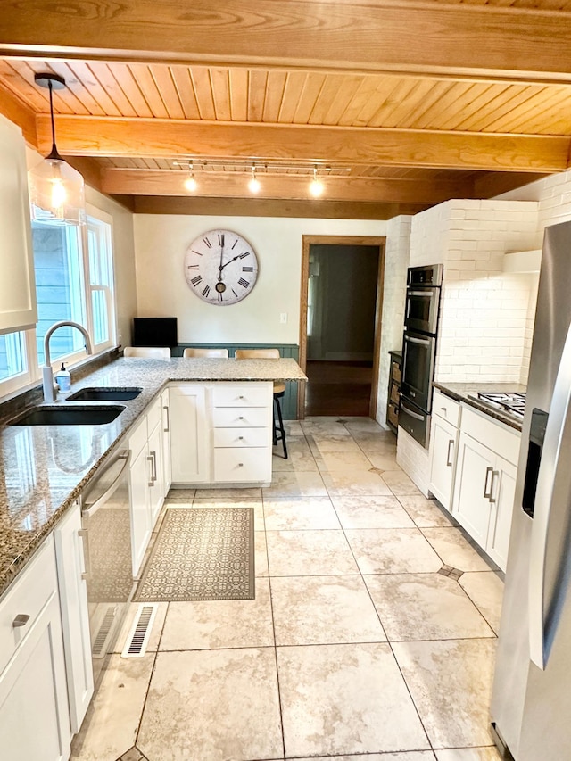 kitchen with stainless steel appliances, white cabinets, wooden ceiling, and a sink
