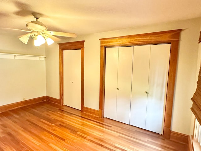 unfurnished bedroom with a closet, light wood-type flooring, baseboards, and a ceiling fan