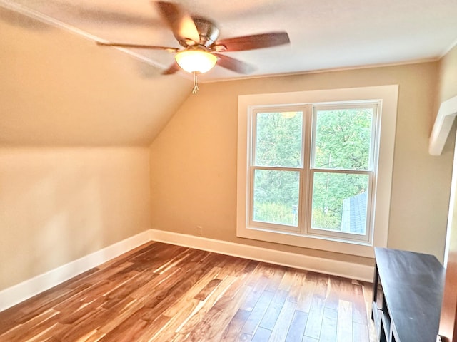 additional living space featuring baseboards, hardwood / wood-style floors, a ceiling fan, and lofted ceiling