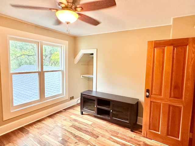 unfurnished room with light wood finished floors, baseboards, and ceiling fan