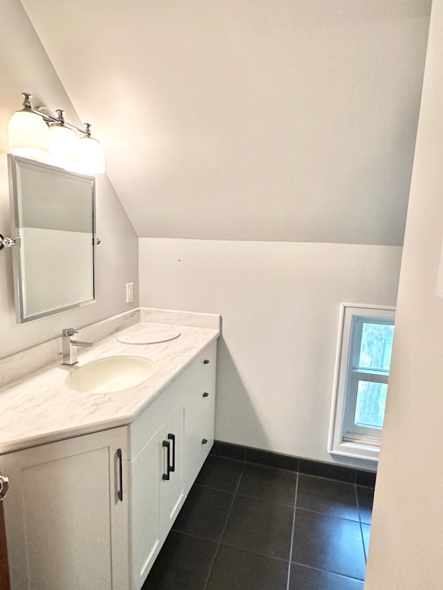 bathroom featuring vanity, vaulted ceiling, and tile patterned flooring