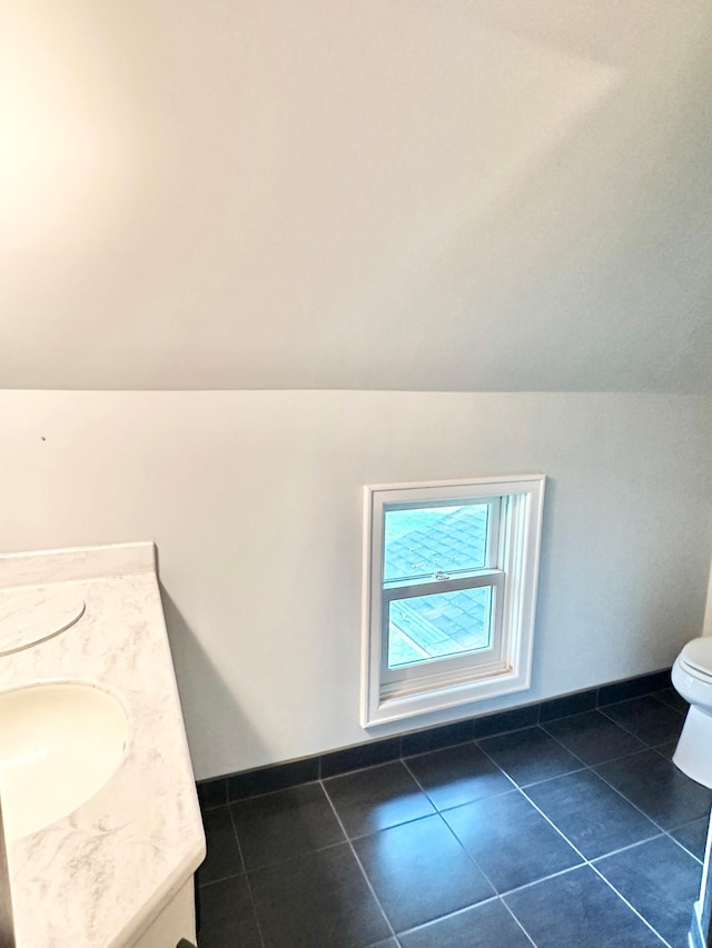 bathroom featuring vanity, vaulted ceiling, toilet, and tile patterned flooring