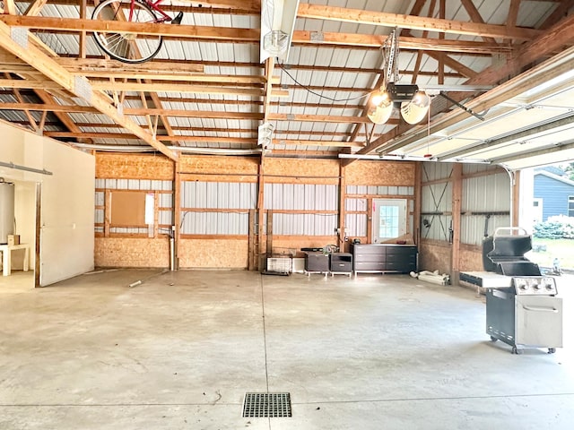 garage featuring water heater, visible vents, and a garage door opener