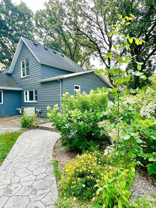 rear view of house featuring roof with shingles