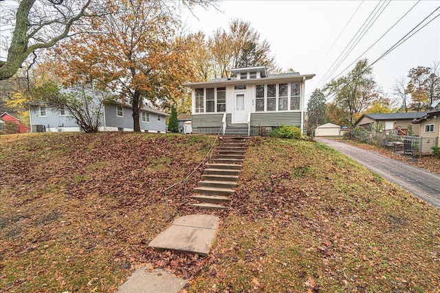 view of front facade featuring an outbuilding and a sunroom