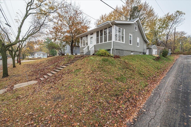 view of side of property featuring a garage and a sunroom