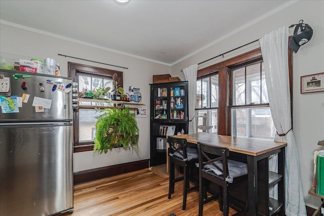 dining room featuring ornamental molding and light hardwood / wood-style flooring