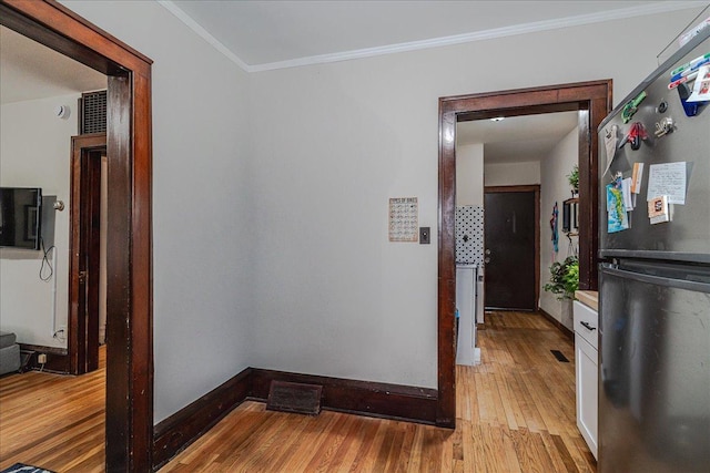 hallway with light wood-type flooring and ornamental molding